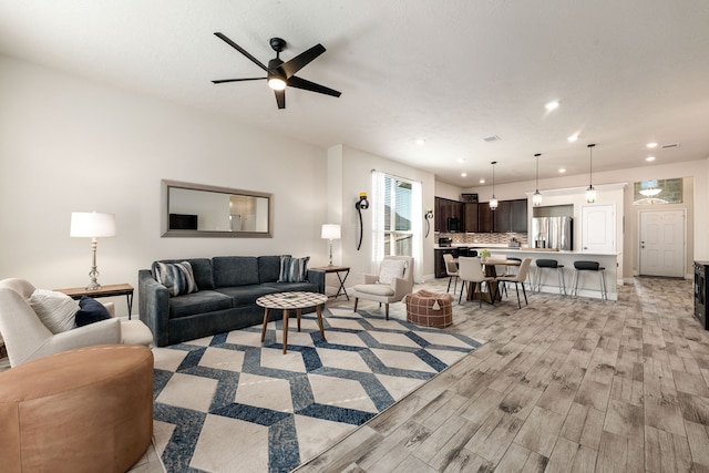 living area with a ceiling fan, recessed lighting, and light wood-style floors