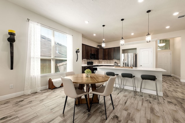 dining area featuring recessed lighting, light wood-style flooring, and baseboards