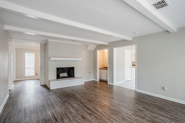 10610 Dunbrook Dr, Houston, TX 77070 - unfurnished living room with dark wood-style floors, baseboards, a brick fireplace, and beamed ceiling