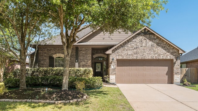 110 Springshed Pl, Montgomery, TX 77316 - view of front facade featuring a garage, brick siding, concrete driveway, and fence