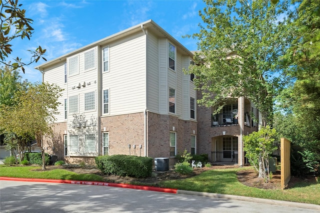 6607 Lake Woodlands Dr Unit 124, The Woodlands, TX 77382 - view of property exterior with brick siding and central air condition unit