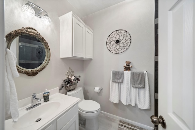bathroom with baseboards, vanity, and toilet