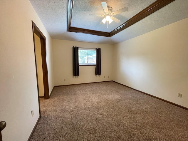 spare room with a ceiling fan, carpet flooring, a textured ceiling, and a raised ceiling