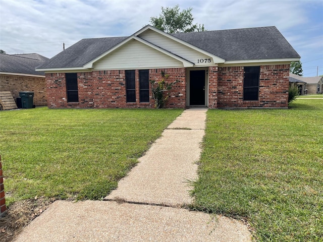 view of front of house featuring a front lawn, brick siding, and a shingled roof