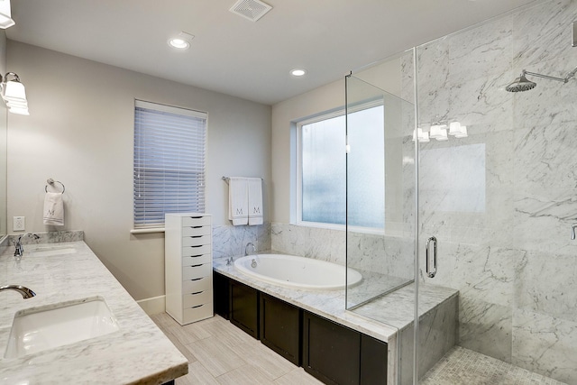bathroom featuring a shower stall, a garden tub, visible vents, and a sink