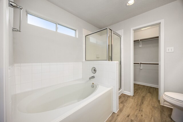6723 Cypress Glades Dr, Katy, TX 77449 - bathroom featuring a bath, toilet, wood finished floors, a shower stall, and a walk in closet