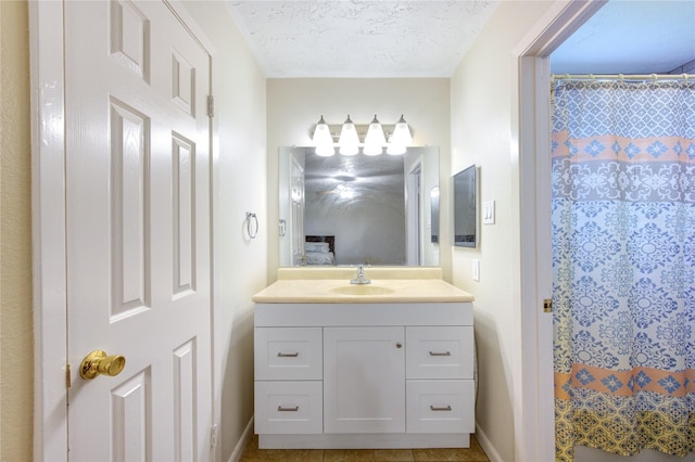bathroom featuring curtained shower, baseboards, a textured ceiling, and vanity