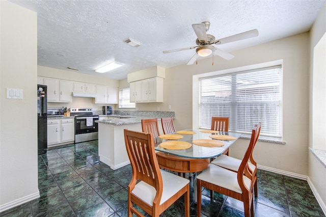 dining space with a textured ceiling, visible vents, a ceiling fan, and baseboards