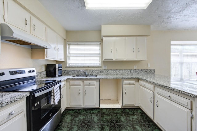 kitchen featuring a textured ceiling, stainless steel electric range oven, under cabinet range hood, and a sink