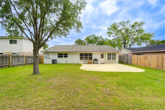 rear view of property with a fenced backyard, central AC unit, a yard, and a patio area
