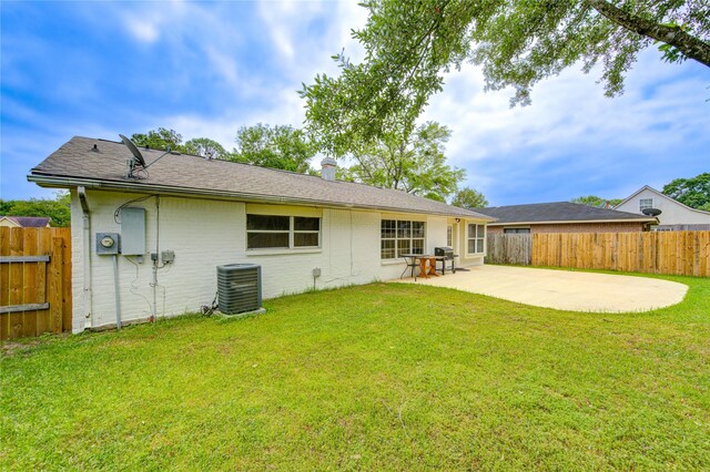 back of house featuring a lawn, central AC unit, fence, and a patio area