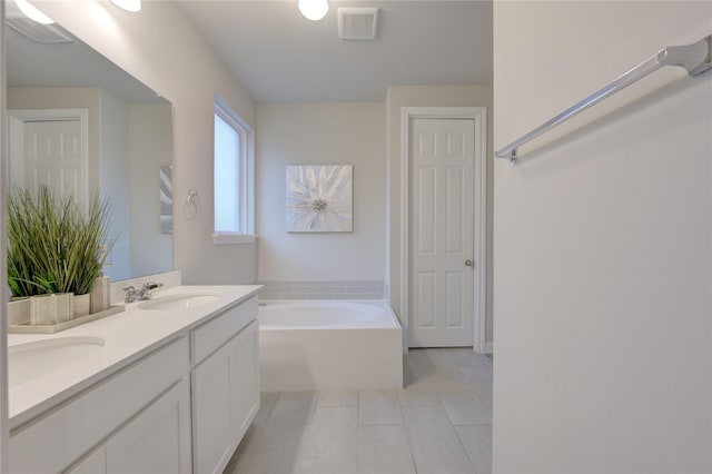 full bath with a bath, a sink, double vanity, visible vents, and tile patterned flooring
