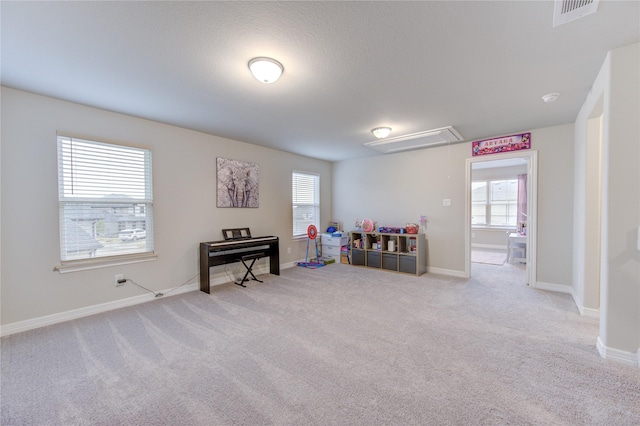 recreation room featuring attic access, baseboards, visible vents, and carpet floors