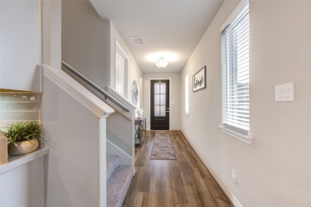entryway featuring baseboards, visible vents, dark wood-type flooring, and stairway