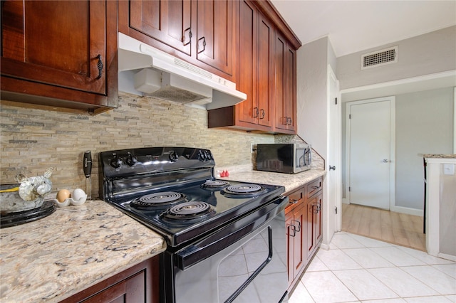 kitchen with range with electric cooktop, stainless steel microwave, backsplash, under cabinet range hood, and visible vents
