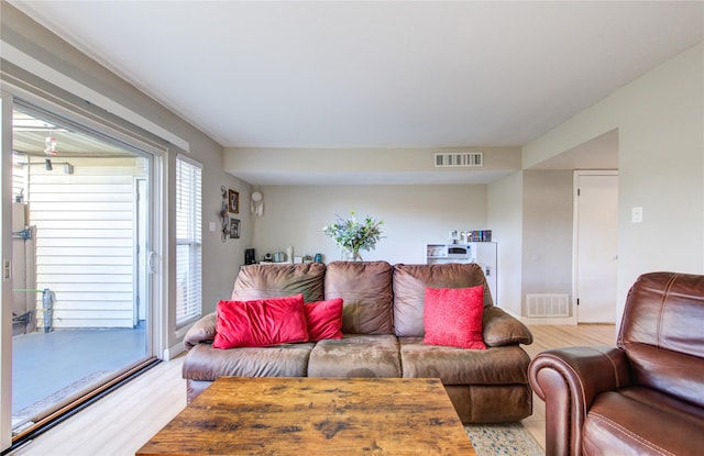 living area featuring light wood-style flooring and visible vents