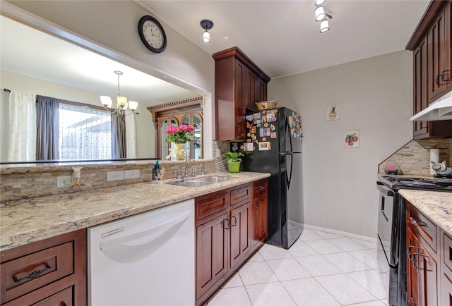 kitchen featuring under cabinet range hood, backsplash, a sink, black appliances, and a chandelier
