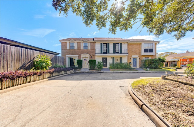 view of front of home with brick siding and fence