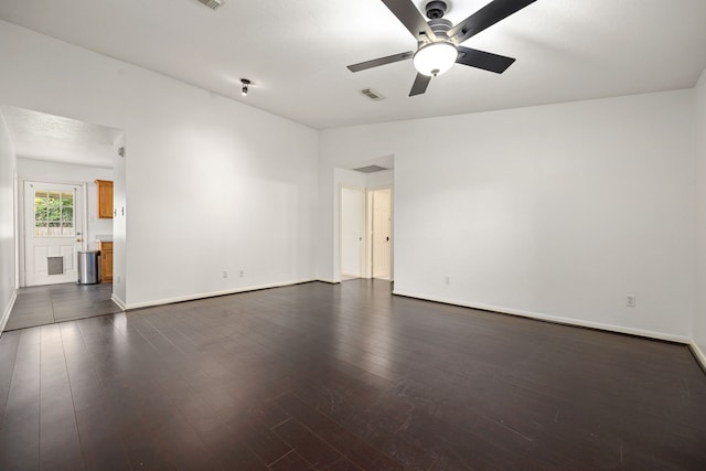 unfurnished room featuring baseboards, dark wood-style flooring, ceiling fan, and visible vents