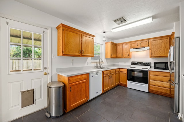 kitchen featuring white dishwasher, black microwave, electric range oven, a sink, and under cabinet range hood