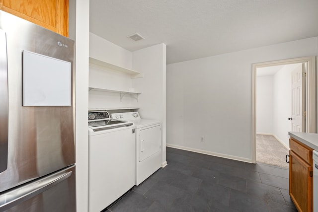 clothes washing area featuring separate washer and dryer, baseboards, laundry area, and visible vents