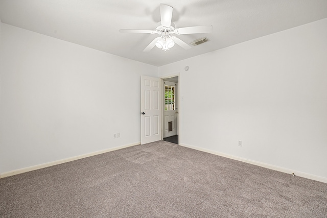 empty room featuring carpet floors, a ceiling fan, baseboards, and visible vents