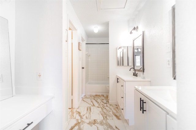 bathroom featuring a sink, marble finish floor, toilet, shower / bathtub combination, and two vanities