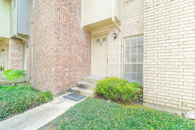 doorway to property featuring brick siding
