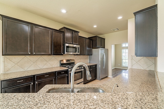 18922 Deer Trace Dr, Crosby, TX 77532 - kitchen featuring a sink, baseboards, dark brown cabinetry, visible vents, and appliances with stainless steel finishes