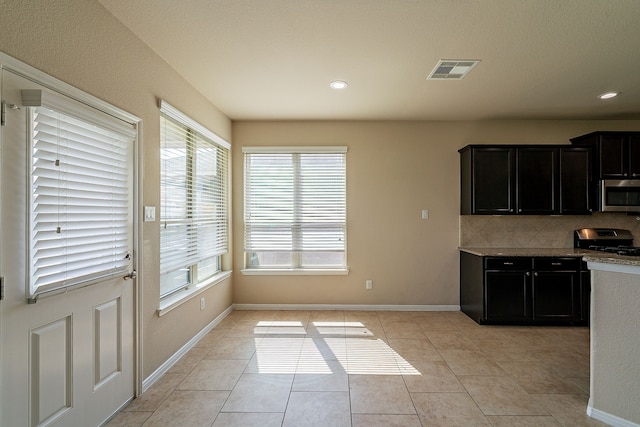 18922 Deer Trace Dr, Crosby, TX 77532 - kitchen featuring stainless steel appliances, visible vents, light tile patterned floors, baseboards, and decorative backsplash