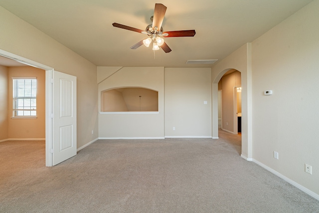 18922 Deer Trace Dr, Crosby, TX 77532 - empty room with light colored carpet, ceiling fan, arched walkways, and baseboards