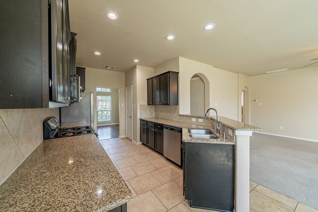 18922 Deer Trace Dr, Crosby, TX 77532 - kitchen featuring a peninsula, a sink, backsplash, gas range oven, and dishwasher