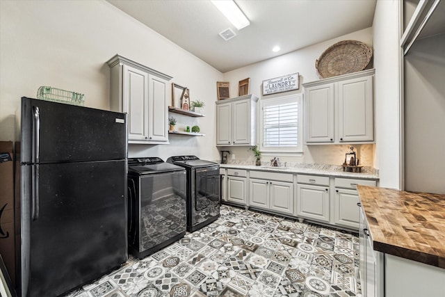 laundry room with visible vents, a sink, cabinet space, and independent washer and dryer