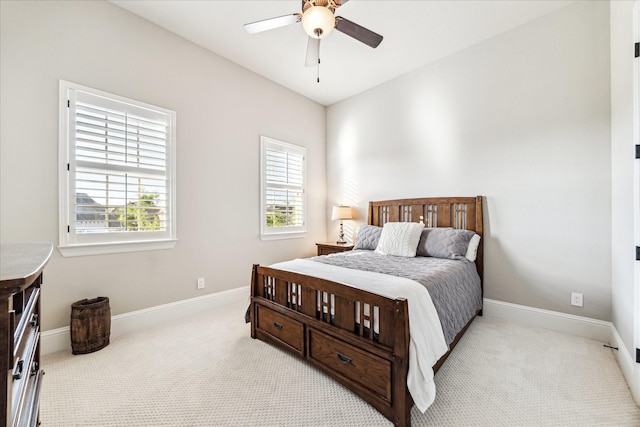 carpeted bedroom featuring a ceiling fan, baseboards, and multiple windows