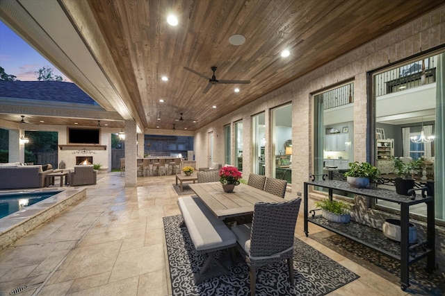 exterior space with wooden ceiling, ceiling fan, recessed lighting, and stone tile flooring