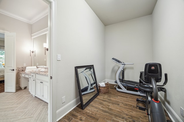 workout area featuring crown molding, baseboards, and light wood-style flooring