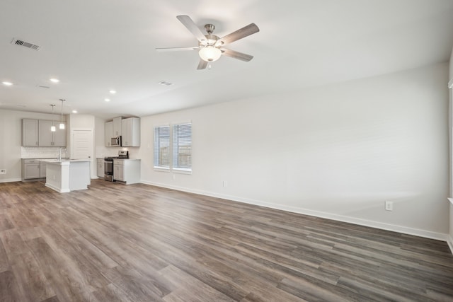 7746 Beaufort Ln, Baytown, TX 77523 - unfurnished living room with recessed lighting, dark wood-type flooring, baseboards, ceiling fan, and a sink