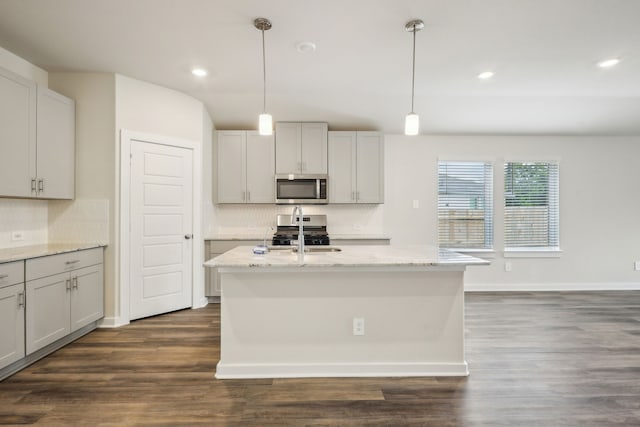 7746 Beaufort Ln, Baytown, TX 77523 - kitchen featuring stainless steel appliances, tasteful backsplash, light stone counters, an island with sink, and recessed lighting