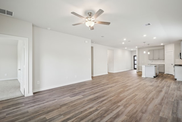 7746 Beaufort Ln, Baytown, TX 77523 - unfurnished living room with recessed lighting, a sink, ceiling fan, wood finished floors, and baseboards