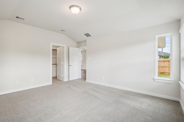 7746 Beaufort Ln, Baytown, TX 77523 - unfurnished bedroom featuring vaulted ceiling, baseboards, light carpet, and a spacious closet
