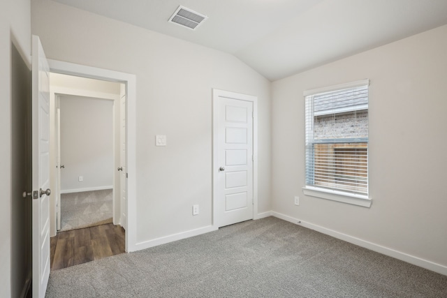 7746 Beaufort Ln, Baytown, TX 77523 - unfurnished bedroom featuring carpet flooring, vaulted ceiling, and baseboards