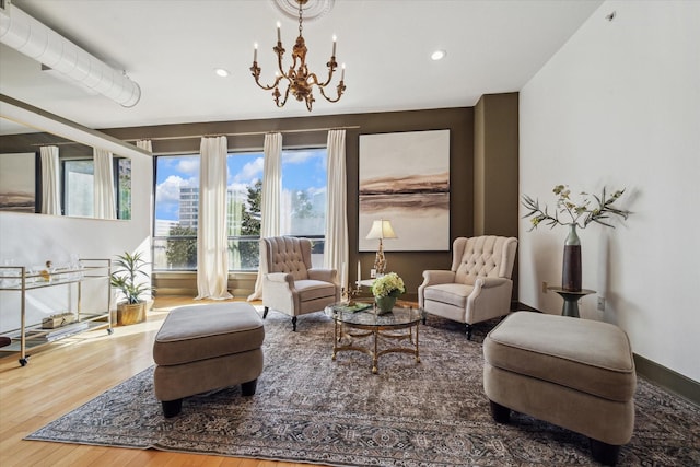 living area with recessed lighting, wood finished floors, and an inviting chandelier