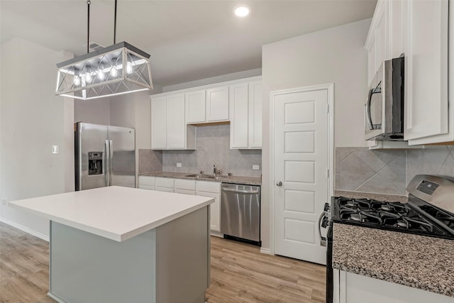 438 Camas Creek Ln, Magnolia, TX 77354 - kitchen with a sink, stainless steel appliances, light wood finished floors, backsplash, and white cabinets