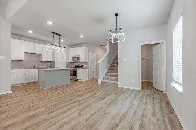 438 Camas Creek Ln, Magnolia, TX 77354 - kitchen featuring a chandelier, light wood-type flooring, stainless steel appliances, and backsplash