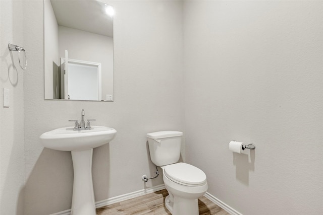 438 Camas Creek Ln, Magnolia, TX 77354 - bathroom featuring toilet, wood finished floors, baseboards, and a sink
