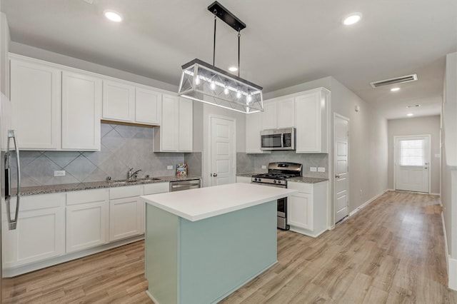 438 Camas Creek Ln, Magnolia, TX 77354 - kitchen featuring a sink, white cabinetry, visible vents, backsplash, and appliances with stainless steel finishes