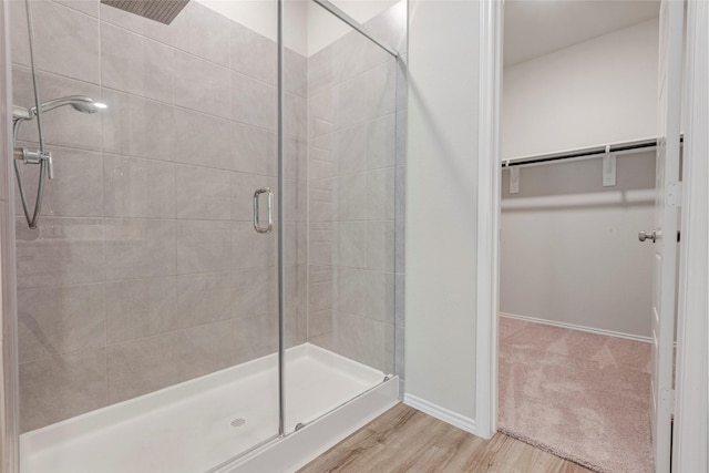 438 Camas Creek Ln, Magnolia, TX 77354 - full bath featuring a shower stall, baseboards, wood finished floors, and a walk in closet