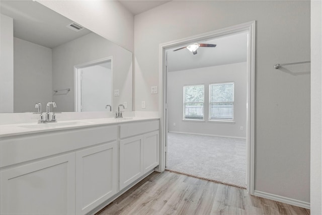 438 Camas Creek Ln, Magnolia, TX 77354 - bathroom with double vanity, visible vents, a sink, and wood finished floors
