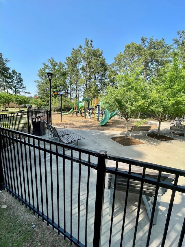 438 Camas Creek Ln, Magnolia, TX 77354 - view of patio with fence and a playground