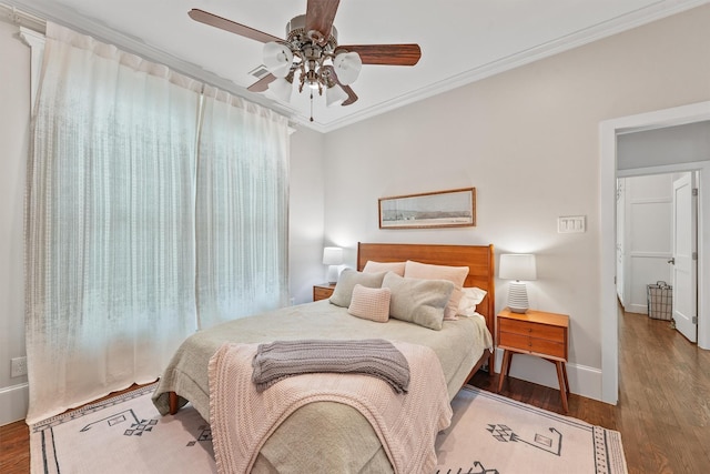 bedroom with wood finished floors, a ceiling fan, baseboards, and ornamental molding